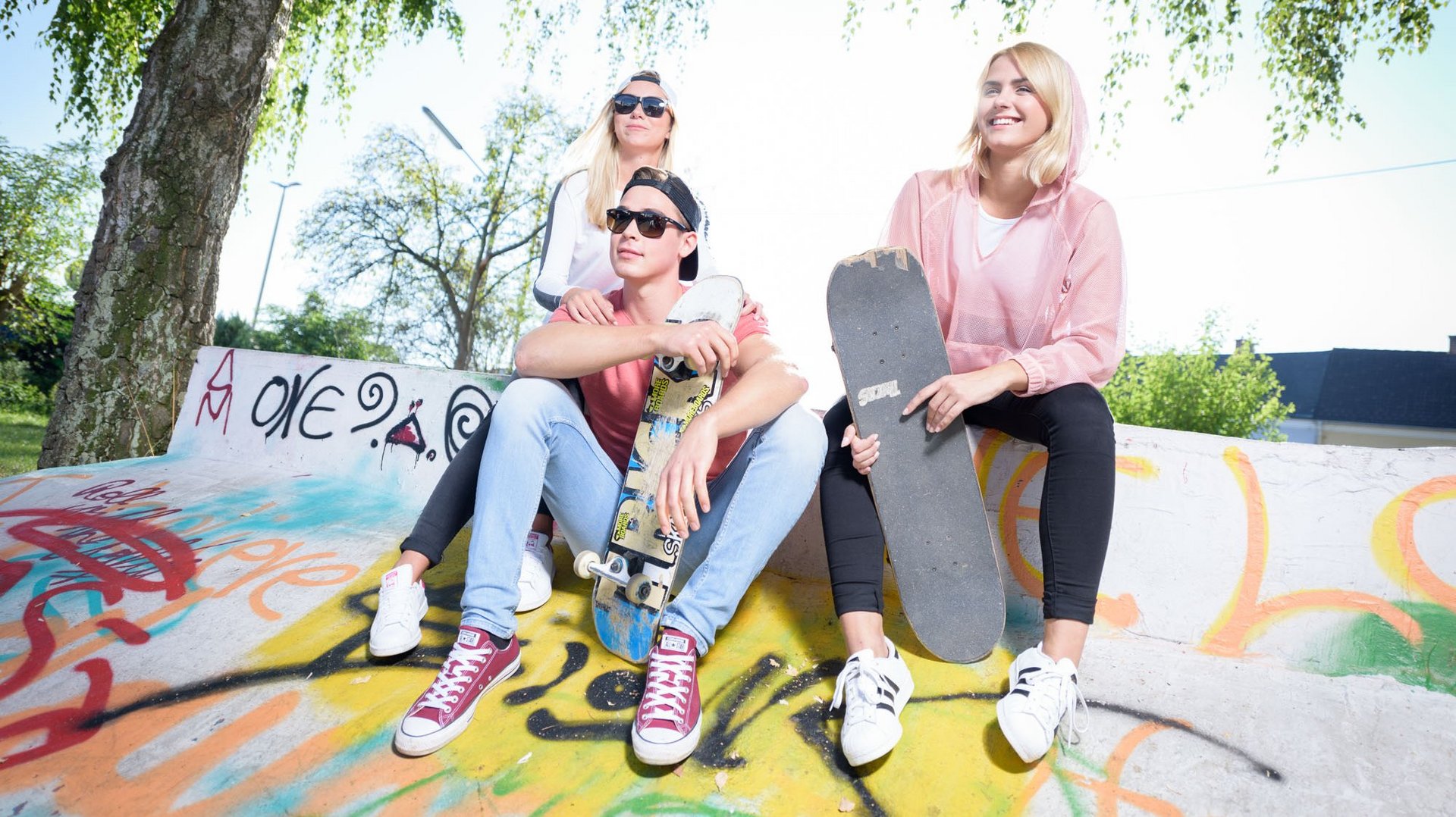 Jugendliche draußen mit Skateboard auf einer Skateboardrampe