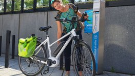Foto: Person mit Fahrrad vor E-Ladestation