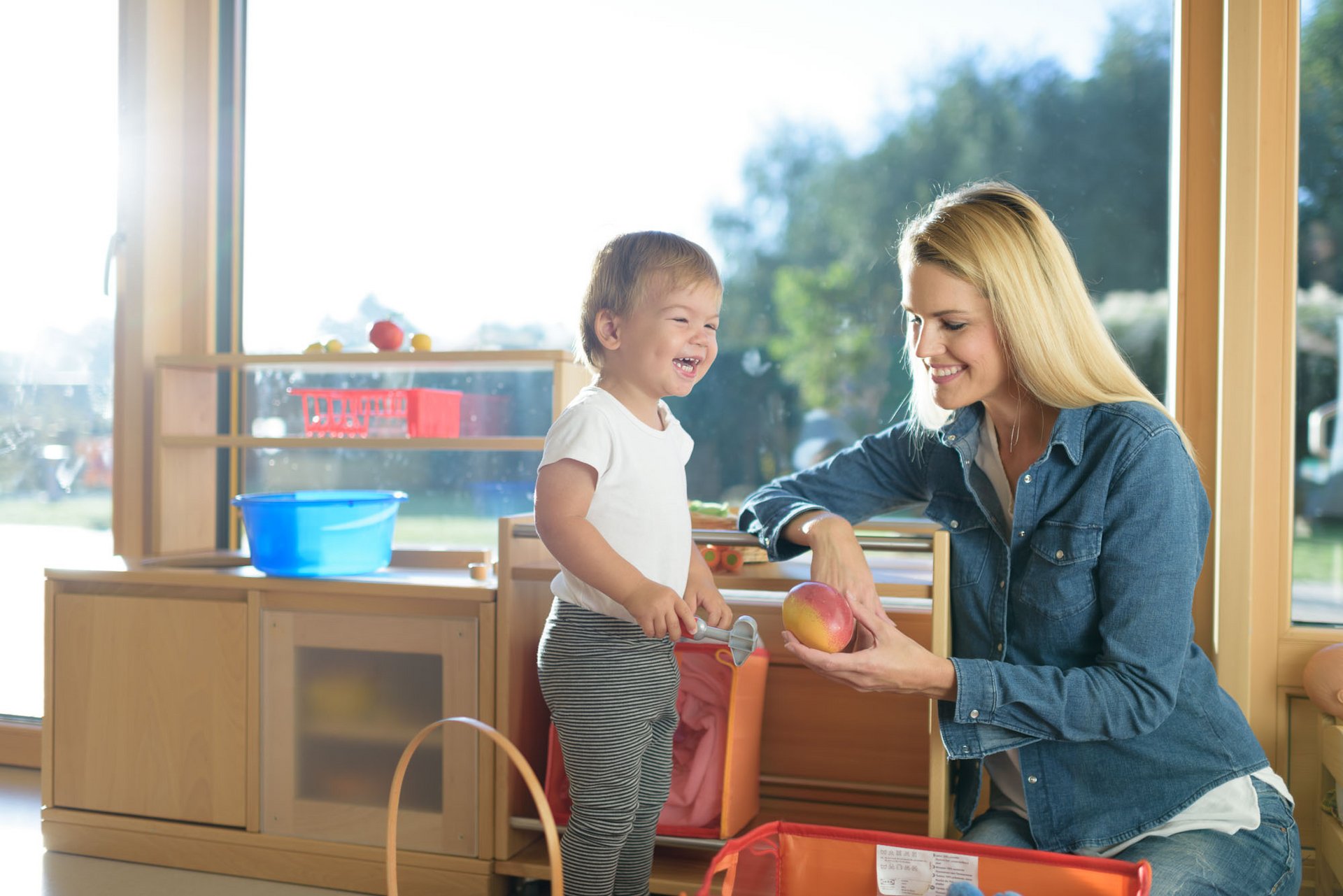 Mama mit lächelndem Kind in der Spielküche