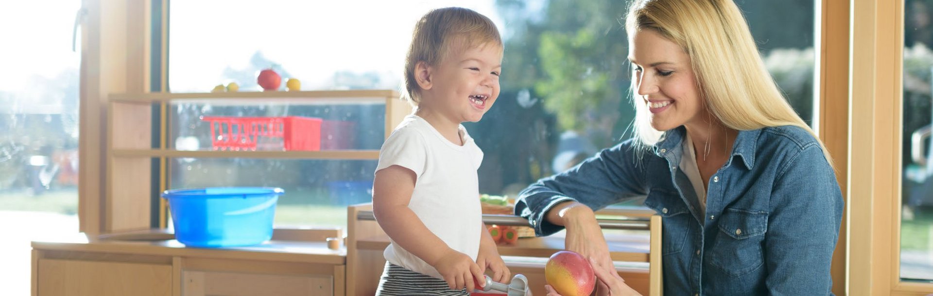 Mutter und lächelndes Kind in der Spielküche